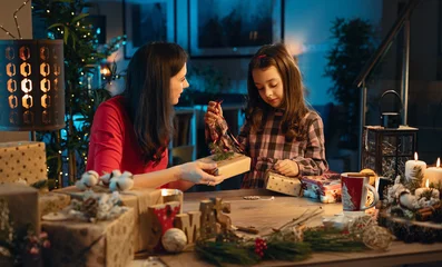 Foto op Plexiglas anti-reflex Mom and her daughter prepaaring gifts for Christmas © konradbak