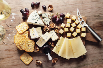 Different arts of cheese with grape on wooden