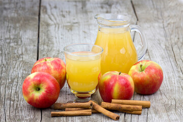 Apple juice and apples on wooden background