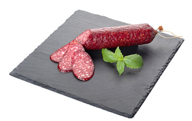 A stick of smoked sausage and slices of sausage on a black cutting board