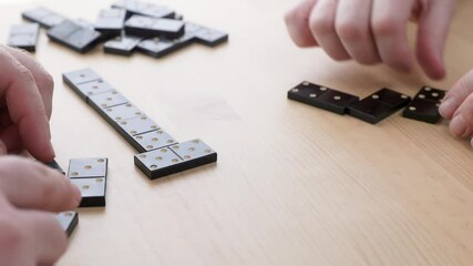 Couple playing dominoes at home. Caucasian husband and wife with Parkinson's disease play dominoes. Close-up of hands. - Powered by Adobe