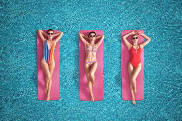 Beautiful young women floating on pink mattress in swimming pool