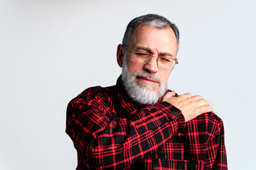 Portrait of mature man isolated on grey background suffering from severe body ache, closing eyes to relieve pain