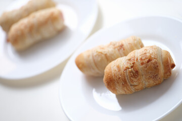 Puff crispy rolls on a white plate, close-up