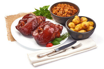 Roasted pork knuckle with baked potatoes and sauerkraut, isolated on white background.