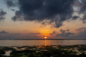 Sunrise over the ocean from the clouds. Visible solar path in the water of the ocean