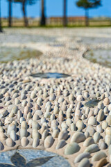 A trail made of small stones for foot massage on the promenade by the sea