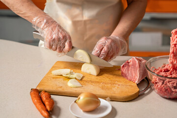 female hands cutting onion for minced meat