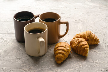 three mugs of coffee and croissants on the table