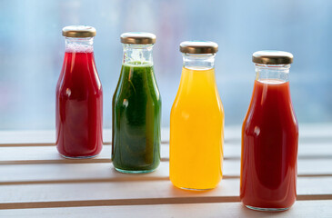 Glass bottles of red, green and yellow smothie