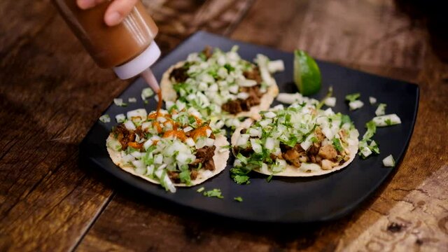 Taco sauce added to food in slow motion in restaurant