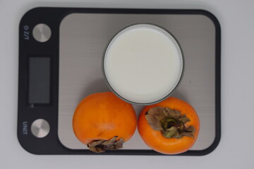 A glass of kefir on the scales. Weight loss, diet and weight control. Still life with healthy food...