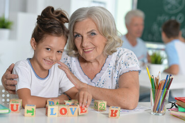 Fototapeta premium Portrait of grandmother and granddaughter with cubes
