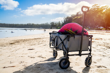 Outdoor beach cart wagon on a sandy beach near the ocean. Family vacation holidays