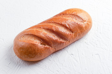 Baguette or loaf on a white concrete background