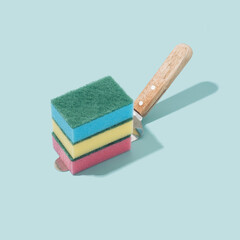 Colorful sponges on a cake spatula and pastel blue background. Immersive reality fantasy concept.