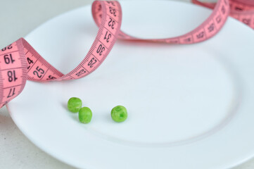 Pink tape measure and green vegetables diet concept