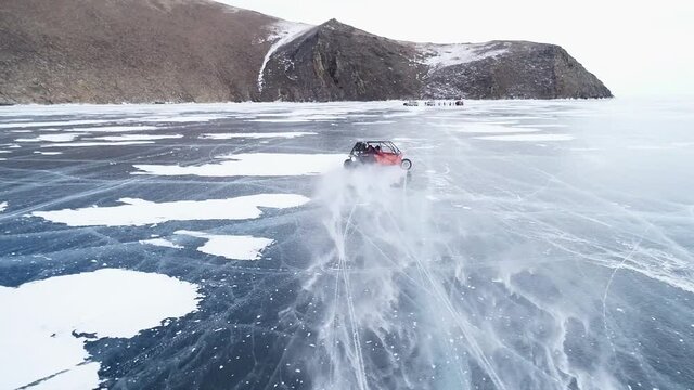 Buggy rides on the ice of frozen Lake Baikal. Homemade buggy rushes at high speed along the icy road
