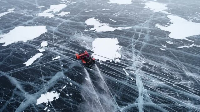 Buggy rides on the ice of frozen Lake Baikal. Homemade buggy rushes at high speed along the icy road