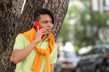 Handsome young latino man using his mobile phone in the street.