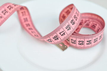 Pink tape measure and green vegetables diet concept