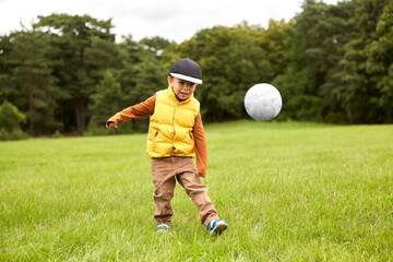 childhood, leisure games and people concept - little boy with soccer ball at summer park