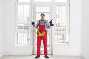 Construction worker putting sealing foam tape on window in house