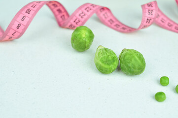 Pink tape measure and green vegetables diet concept
