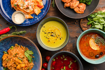 pasta with tomatoes, salmon rolls, vegetable soup, salyanka soup, borsch soup top view on a wooden background