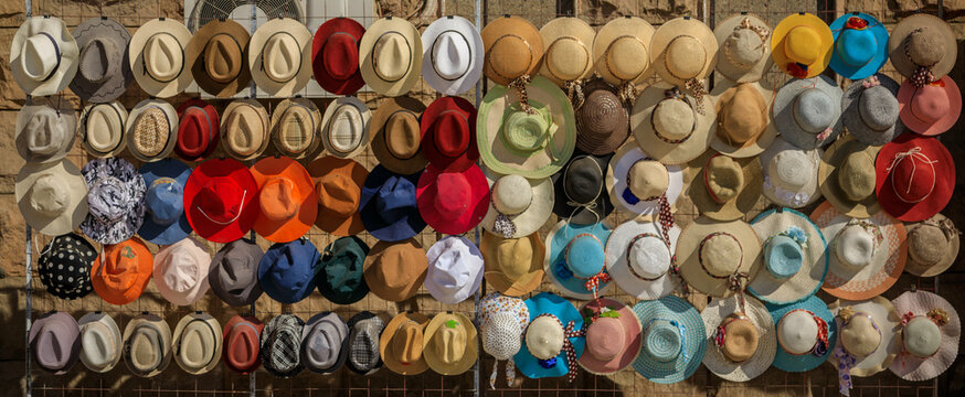 Bunte Hüte auf einem Gestell nebeneinander auf einem Markt, Basar, Panoramafoto