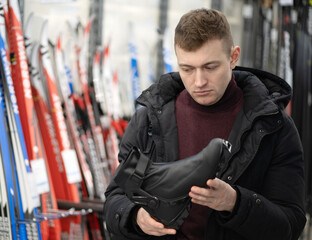 A man chooses ski boots for professional skiing.