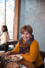 Portrait of healthy older woman eating at  restaurant