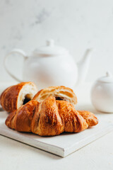 close-up on croissants on the background of a white teapot on a white background