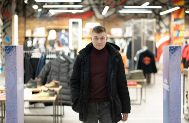 Photo of a handsome brunet young man in a store in a mall. Shopping concept