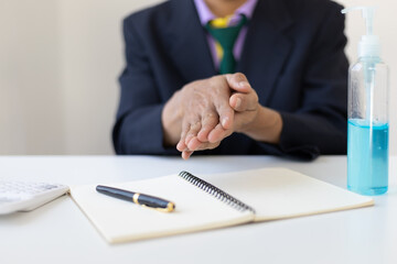Businesspeople use hand sanitizer before working in the office.
