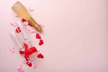 Valentines day greeting card with champagne bottle, gift box, red ribbon and envelope with blank note mockup inside on pink background. Top view with space for greetings. Greeting card with copy space