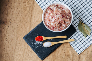 raw minced fresh meat on a wooden background spice pepper wooden spoon
