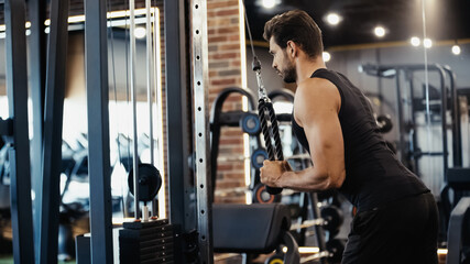 Fototapeta na wymiar bearded sportsman exercising on fitness machine in sports center.