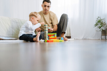 White boy playing with toys while spending time with his father