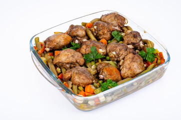 Glass dish with baked vegetables and chicken pieces. Studio Photo