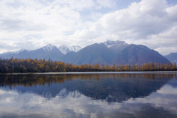 Mountain lake in the taiga and Kodar ridge