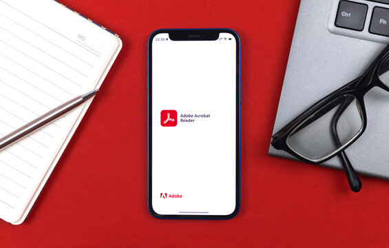 Adobe Acrobat Reader application logo. Business desktop background, top view photo