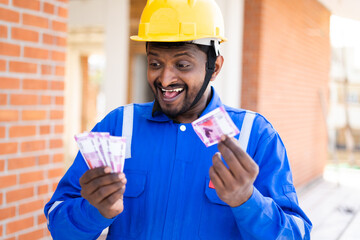 excited happy plumber after seeing or counting Money - concept of repairman received payment for...