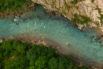 Mountain beautiful river with clear blue water, in the middle of the forest and stones. Natural untouched nature. Top view.