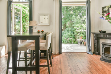 Interior of cozy dining room in cottage viewed to backyard