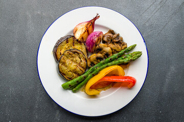 grilled vegetables on a plate on grey concrete table top view