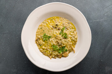risotto with porcini mushrooms on grey concrete table top view