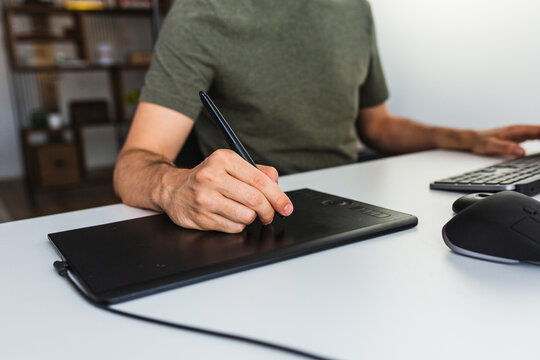 Anonymous male drawing on graphic tablet