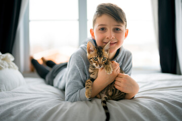 Bengal cat in the bed room with child boy