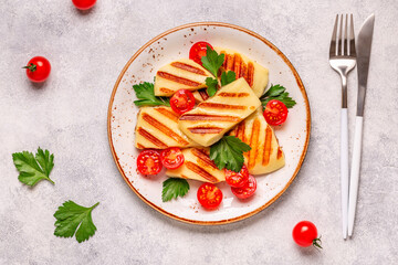 Fototapeta na wymiar Grilled halloumi cheese served with tomatoes and parsley